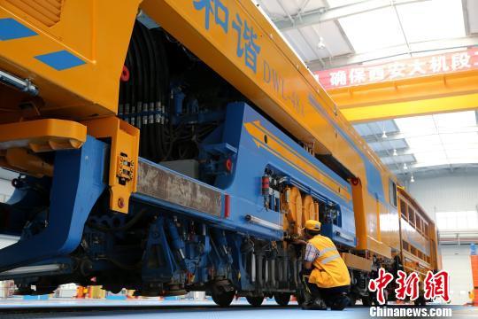 圖為工人正在清理大型養(yǎng)路機(jī)械。　張遠(yuǎn) 攝